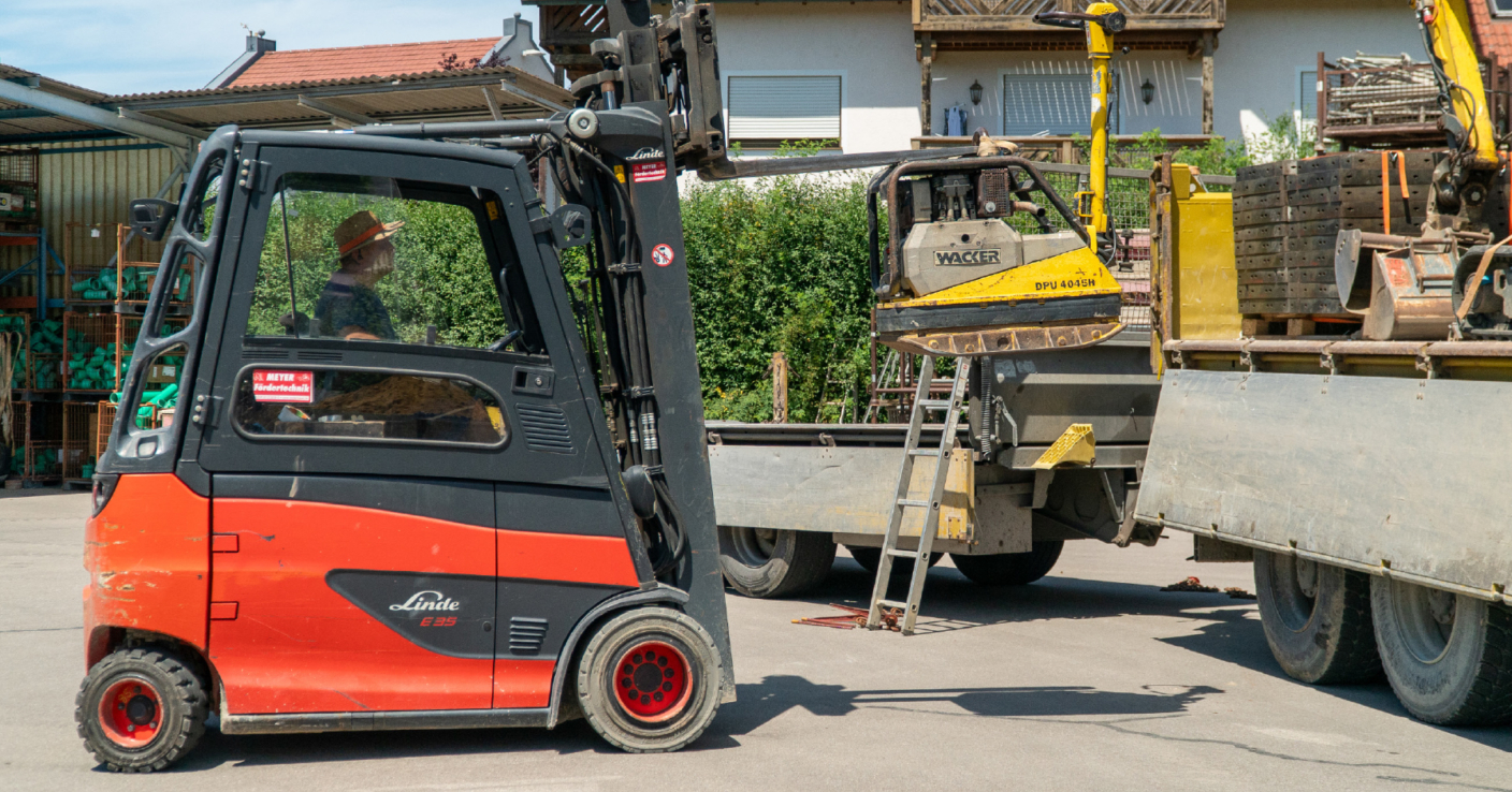 Gabelstapler lädt eine Rüttelmaschine auf einen Transporter
